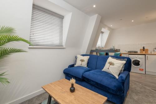 a living room with a blue couch and a table at Thornhill House by Guestz in Wakefield