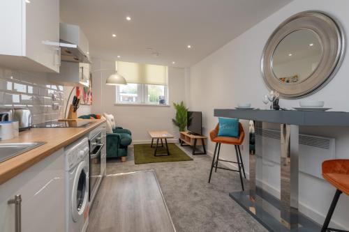 a kitchen and living room with a sink and a dishwasher at Thornhill House by Guestz in Wakefield