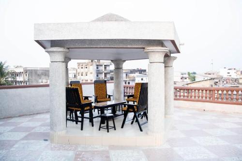 cenador con mesa y sillas en la azotea en Magnifique Appartement - Cotonou - Avotrou Apkapka en Cotonú