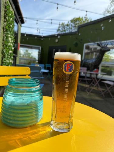 a glass of beer sitting on a yellow table at King Robert Hotel in Stirling