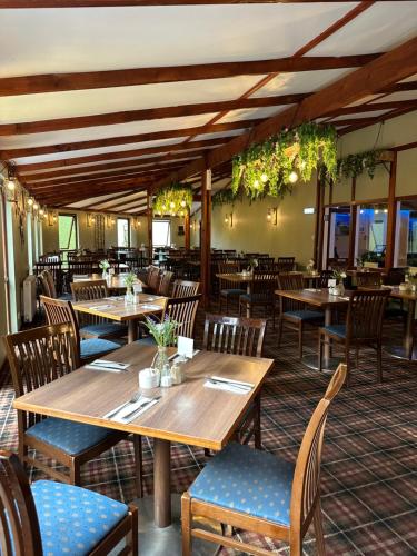 a dining room with wooden tables and chairs at King Robert Hotel in Stirling