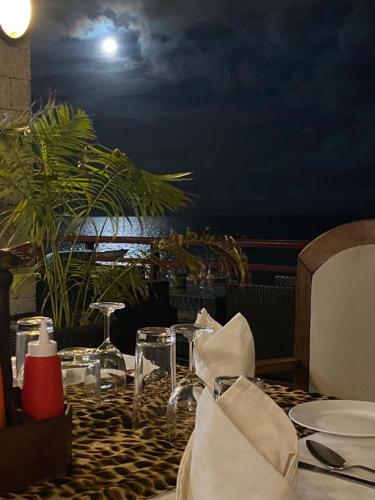 a table with plates and glasses on a table with the moon at Indiana Beach Apartments in Bamburi