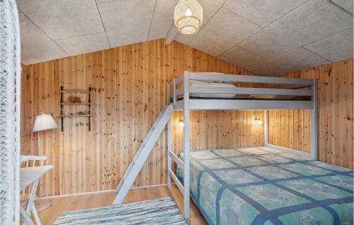 a bedroom with a bunk bed in a wooden wall at Cozy Home In Hjerm With Kitchen in Hjerm