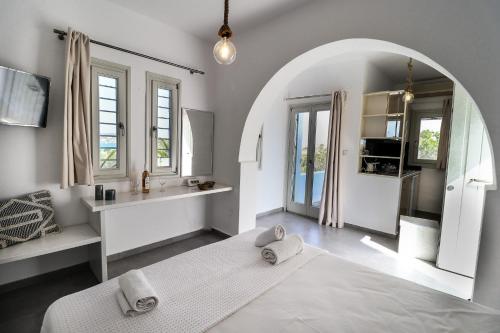 a living room with an archway and a bathroom at Mika Bungalows in Naousa