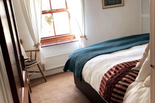 een slaapkamer met een bed en een raam bij Cosy 3 Bed Cottage near 3 Peaks - Log Burner & Aga in High Bentham