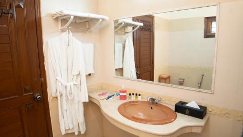 Orchid Inn by WI Hotels في كراتشي: حمام مع حوض ومرآة كبيرة
