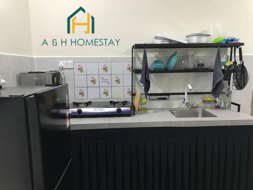 a kitchen with a counter top with a sink at A&H Homestay Teluk Intan in Teluk Intan