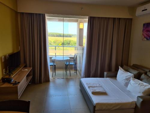 a hotel room with a bed and a view of a table at Ideal para famílias, hospede-se no Solar das Águas. in Olímpia