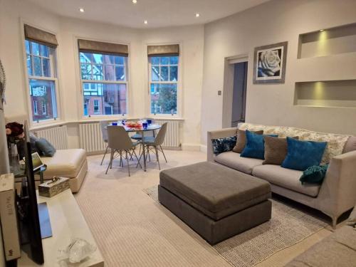 a living room with a couch and a table at Quintessentially 'London' flat in London