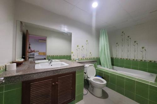 e bagno con lavandino, servizi igienici e vasca. di Kaewchantra Mansion a Chiang Mai