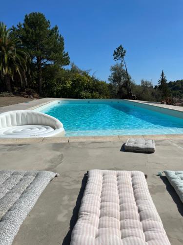 een groot zwembad met twee matrassen ervoor bij Maison individuelle avec piscine à Grasse in Grasse