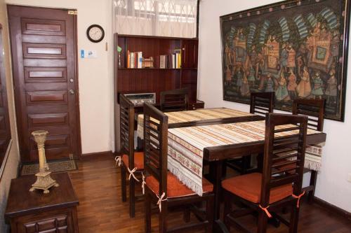 comedor con mesa de madera y sillas en Altura Rooms & Suites, en Quito