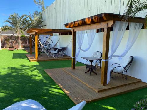 a wooden deck with a gazebo and a table and chairs at Hotel Sambura in Imbé