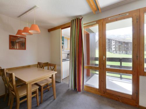 d'une salle à manger avec une table et une porte coulissante en verre. dans l'établissement Studio divisible au pied des pistes avec balcon et casier à skis - FR-1-181-2083, à La Plagne Tarentaise