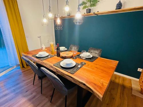 una mesa de madera con sillas y platos. en modern * gemütlich * Nespresso * Terrasse * Netflix en Duisburg