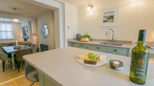 a bottle of wine and a plate of fruit on a kitchen counter at 9 Rose Hill in Beaumaris