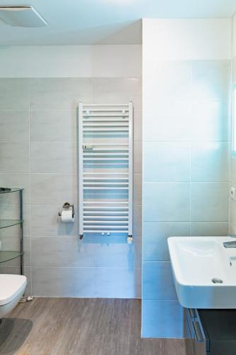 a white bathroom with a sink and a toilet at Morgenrot in Dranske