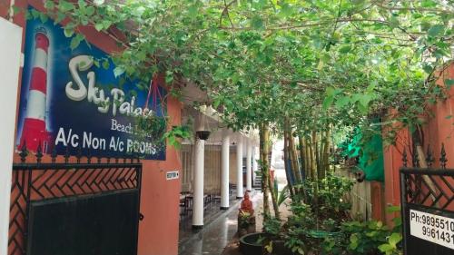 a street with trees in front of a building at Sky Palace Beach Hotel in Trivandrum