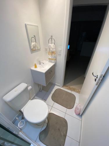 a bathroom with a white toilet and a sink at Lar de piatã 2 quartos in Salvador