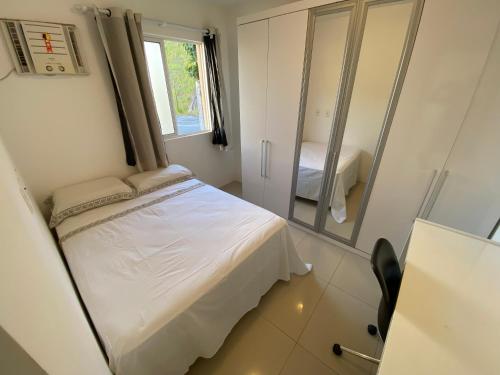 a small bedroom with a bed and a mirror at Lar de piatã 2 quartos in Salvador