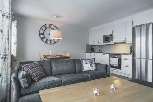a living room with a couch and a kitchen at Trillevallens Högfjällshotell & Lägenheter in Trillevallen
