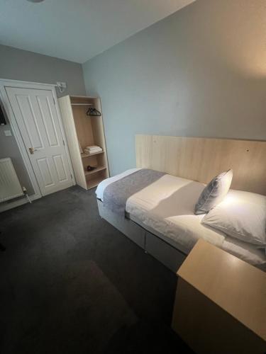 a bedroom with a bed and a table and a door at Holborn Hotel in Thurso
