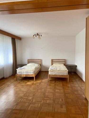 two beds in a room with wooden floors at Ruhige 4 Zimmer EG-Wohnung Z1 in Königsbronn