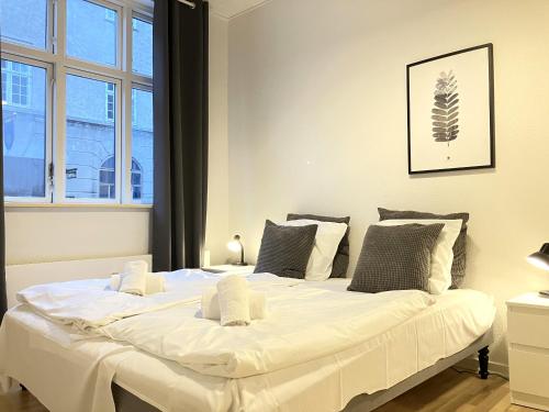 Cette chambre comprend un grand lit blanc et une fenêtre. dans l'établissement 2 Bedroom Apartment In Odense City Center, à Odense