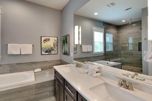 Un baño con dos lavabos y un espejo grande. en Great Escape at Blue Mountain Beach, en Santa Rosa Beach