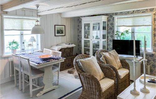 a dining room with a table and chairs and a television at 1 Bedroom Lovely Home In Trosa in Trosa