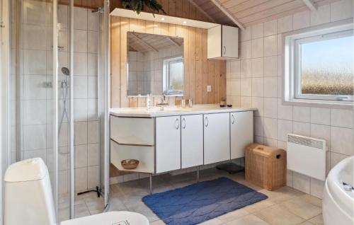ein Bad mit einem Waschbecken, einer Dusche und einem Spiegel in der Unterkunft 4 Bedroom Amazing Home In Bog By in Bogø By
