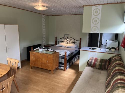 フェリェスターデンにあるNice cottage within walking distance to Farjestadenのベッドルーム1室(ベッド1台、テーブル、ソファ付)
