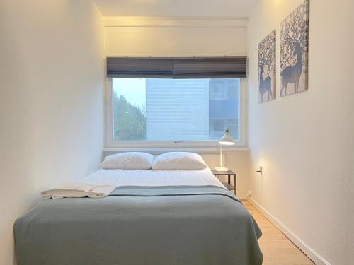 a bedroom with a large bed with a window at One Bedroom Apartment In Valby, Langagervej 64, in Copenhagen