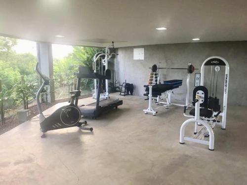 a gym with treadmills and machines in a room at Bangalô jacuzzi Villas pratagy in Maceió