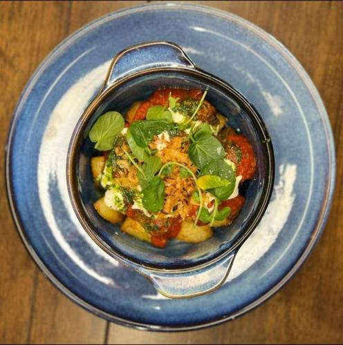 a blue bowl of food on a blue plate at The 1645 Inn in Nairn