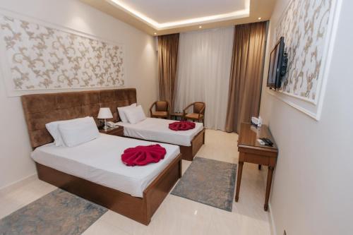 two beds in a hotel room with red roses on them at Ramage Hotel & Resort in Cairo