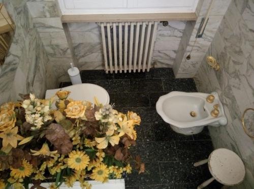 bagno con lavandino e fiori sul pavimento di IVO'S VILLA ad Altopascio