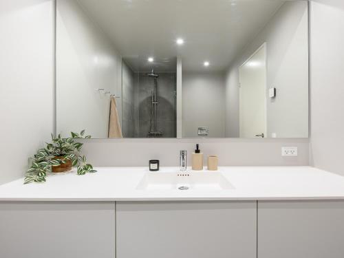 ein weißes Badezimmer mit einem Waschbecken und einem Spiegel in der Unterkunft Sanders View Copenhagen - Fabulous Two-Bedroom Apartment with Harbor View in Kopenhagen