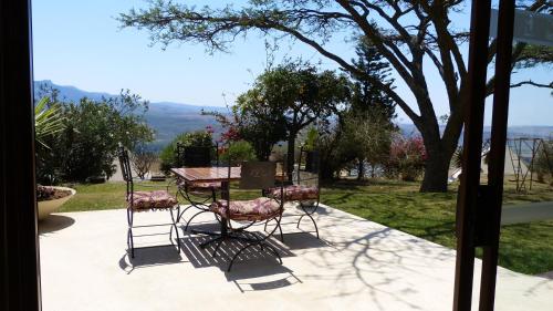 a table and two chairs sitting next to a tree at Pyramids Motel in Van Reenen
