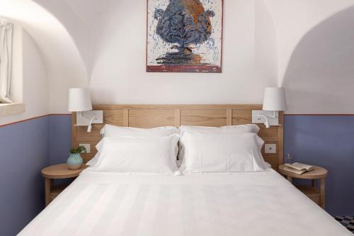 a bedroom with a large bed with white pillows at Masseria Auraterrae in Polignano a Mare