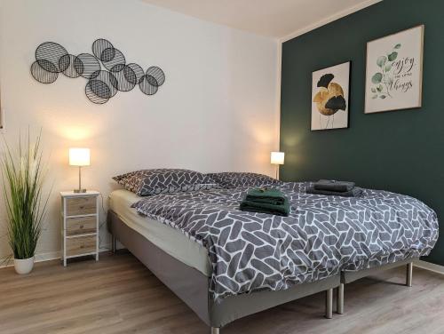 um quarto com uma cama e uma parede verde em K-TOWN GREEN Studio Apartment em Kaiserslautern