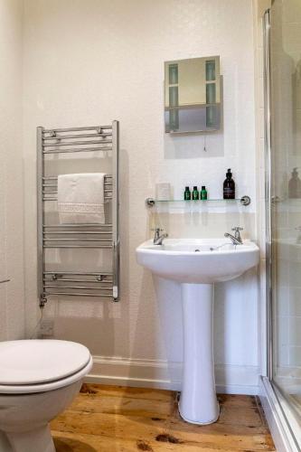 a white bathroom with a sink and a toilet at Cawdor House B&B in Nairn