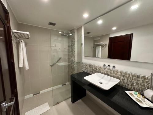a bathroom with a sink and a shower at Hotel Kualamaná Cafam Melgar in Melgar