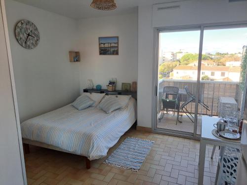 1 dormitorio con 1 cama y balcón en La mer, en Balaruc-les-Bains