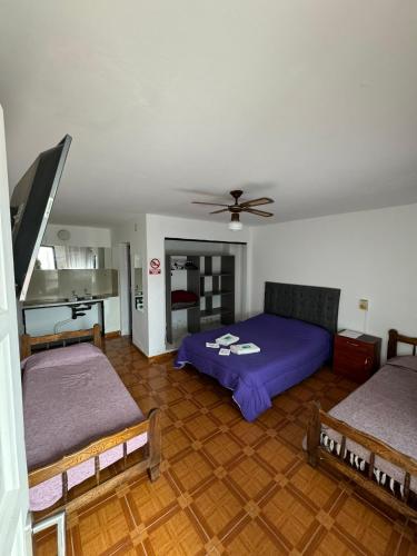 a bedroom with two beds and a ceiling fan at Hotel 4 Ases in Embalse
