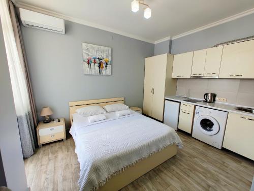1 dormitorio pequeño con 1 cama y cocina en Queen Tamara Apartments, en Makhinjauri