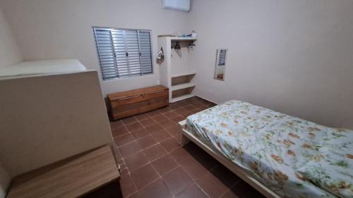 a bedroom with a bed and a tiled floor at Temporada no Paraíso in Ilha Comprida