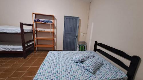 a bedroom with a bed and two bunk beds at Temporada no Paraíso in Ilha Comprida
