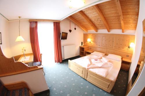 sypialnia z dużym łóżkiem w pokoju w obiekcie Hotel Val w mieście Selva di Val Gardena