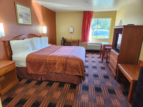 a hotel room with a bed and a television at Days Inn by Wyndham Lumberton in Lumberton